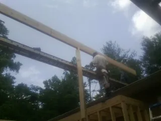 Carpenter setting a ridge beam over a new addition frame — Ice Dam Removal by Roofing Brothers in Northumberland