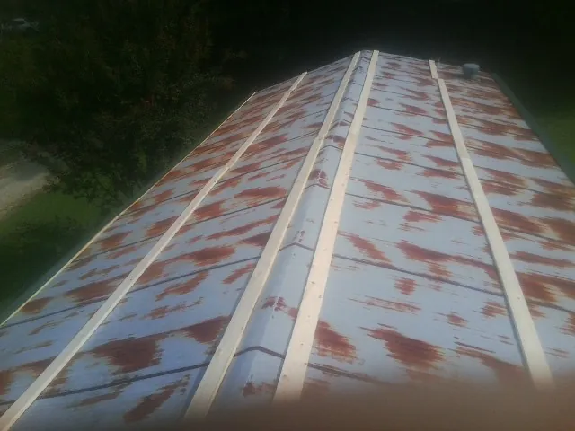 Rusted metal roof panels with new wood purlins before replacement — Storm Damage Roof Repair in Northumberland by Roofing Brothers