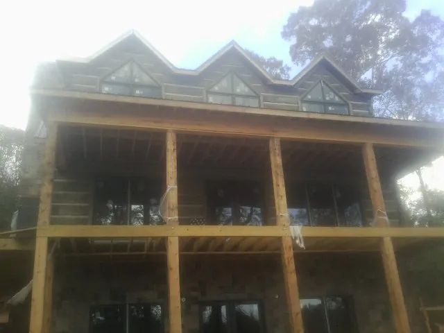 Dormers and porch framing on a large log home under construction — Roof Coating work by our crew in Northumberland