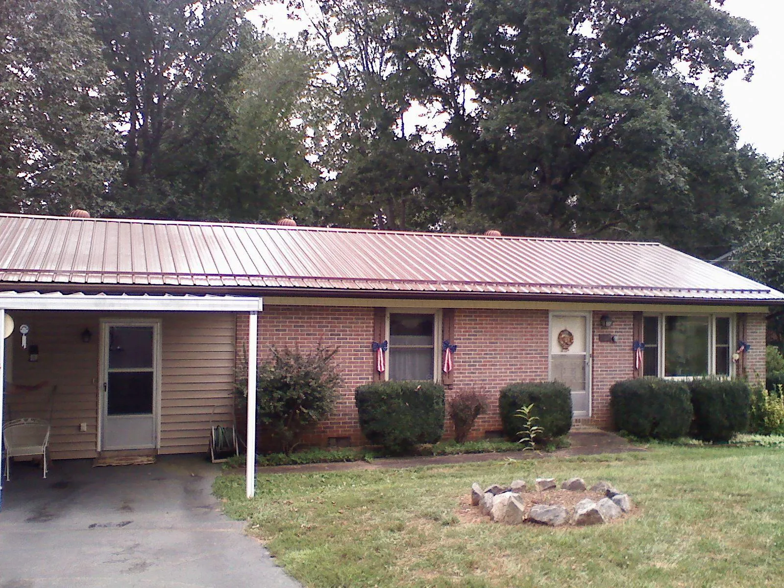 Bronze metal roof and carport on a brick ranch home — Roof Repair work by our crew in Northumberland